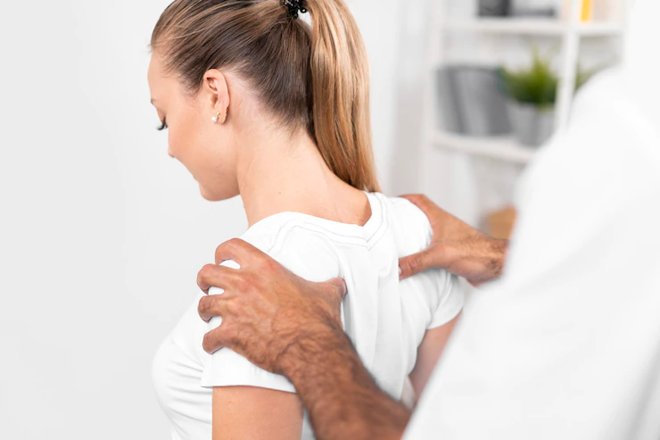 male physiotherapist checking woman s back shoulders 23 2148780737